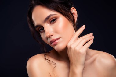 Pürüzsüz makyajlı ve parlak tenli esmer bir kadının göz kamaştırıcı bir portresi..