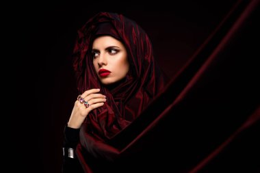 Büyüleyici bir kadın portresi. Şık, lüks bir stili olan, koyu kırmızı bir eşarp takan, zarif ve alımlı bir kadın portresi..