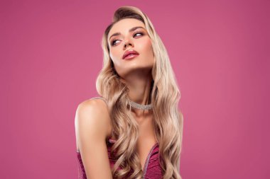 Zarif bir genç kadın portresi, kendine güvenen sarı saçlı, lüks elbiseli ve tamamlayıcı mücevherli, parlak pembe bir arka planda ustalıkla poz vermiş..