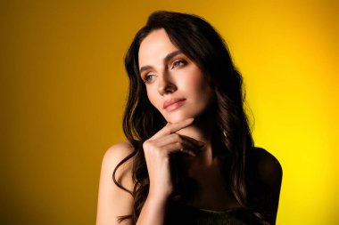 Zarif giyinmiş güzel bir genç bayanın göz kamaştırıcı portresi canlı sarı bir arkaplan karşısında sofistike tarzını ve çarpıcı özelliklerini vurguluyor..