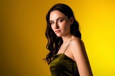 Güzel esmer kadın çekici bir şekilde poz veriyor, pürüzsüz bir stil sergiliyor, parlak bir arkaplan ve şık bir zarafet..