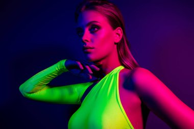 Canlı neon ışıklarla aydınlatılan, çağdaş moda ve güzelliği gözler önüne seren, gece hayatı temalarını ve modern estetiği çağrıştıran şık genç bir kadın..