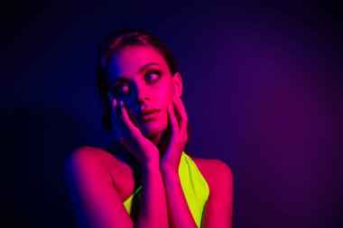 Canlı neon ışıkla aydınlatılmış, modern ve şık bir ruh hali yakalayan, cazibe, moda ve gece hayatını çağrıştıran genç bir kadının yakın çekimi..