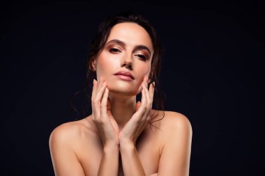 Zarif tenli, zarif esmer bir kadının büyüleyici bir görüntüsü. Siyah bir arkaplana zarif bir şekilde poz veriyor. Güzelliği, tarzı ve kendine güveni vurguluyor..