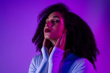 Neon ışıklarının altında kendine güveni olan şık genç bir kadın. Modayı, güzelliği ve kendine güveni kutlayan kozmik ve büyüleyici bir ortam..