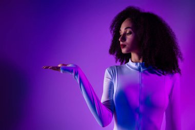 Büyüleyici, fütüristik bir ortamda genç bir kadın, canlı ultraviyole ışıltı, modern moda ve benzersiz estetik çekiciliği var..