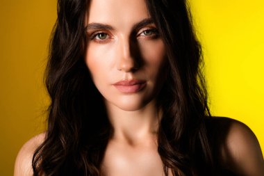 Zarif esmer saçlı, çekici bir genç kadın, doğal güzelliğini, saf sarı bir zemine karşı sergiliyor. Kendine güveni zarafet ve stil yayar..
