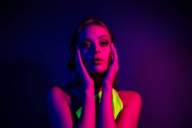 Neon ışıklı genç bir kadının çarpıcı görüntüsü, modern güzellik, moda ve hareketli gece hayatı estetiğinin temalarını vurguluyor..