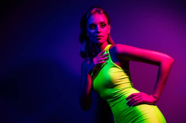 Parlak neon renklerle aydınlatılmış büyüleyici bir manken. Modern gece hayatı, cazibe ve sanatsal stil temaları için ideal. Cesur moda tercihlerini ve canlı ışıklandırmalı çağdaş tasarımı gösterir.