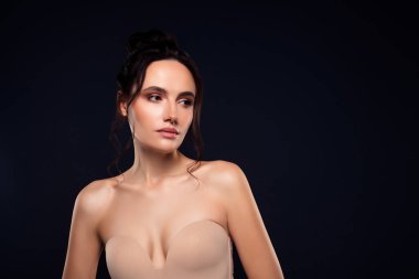 Güzel, esmer bir kadının büyüleyici görüntüsü. Siyah bir arka plana karşı güvenle poz veriyor. Zarafet, doğal güzellik ve sofistike stil sergiliyor..