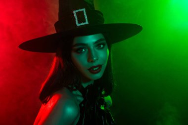 Cadı gibi giyinmiş, yeşil ve kırmızı ışıklı çekici bir kadın cadılar bayramı şenliği ve mistik atmosferini canlandırıyor..