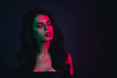 Stylish brunette model illuminated by artistic neon lighting, showcasing a blend of beauty and elegance in a captivating and vibrant setting.