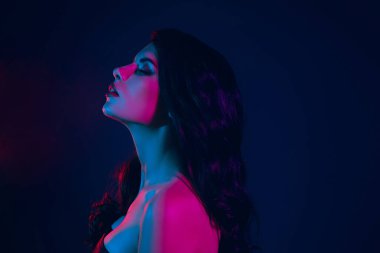 Striking portrait of a stunning woman under vivid neon lights, showcasing modern fashion, beauty, and a mesmerizing allure against a mysterious and dynamic nightlife backdrop.