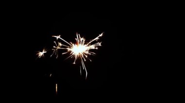 Bengal lights burn in the dark in slow motion. Black background. The concept of Christmas and the New Year. Sparkler concept. Newyear party sparkler.