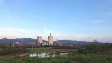 Termik santralin dev boruları üretim sürecinde hafifçe tütüyor. Endüstriyel manzara, atmosfer kirliliği, yanmış yakıt kavramını kullanan elektrik üretimi. Çevre