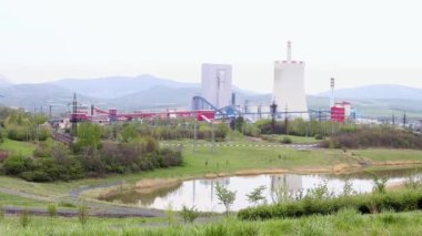 Termik santralin dev boruları üretim sürecinde hafifçe tütüyor. Endüstriyel manzara, atmosfer kirliliği, yanmış yakıt kavramını kullanan elektrik üretimi. Çevre