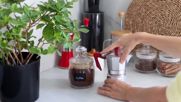 女性の手は 現代のキッチンを背景に銅トルコのコーヒー醸造ポットをひねります 朝食コーヒーのコンセプト 自宅でコーヒーを作るプロセス スローモーション — ストック動画