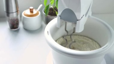 Karıştırıcı hamuru çevirme kabında karıştırıyor. Taşaklı bir karıştırıcı hamuru yoğurur. Yüksek kalite 4k görüntü.