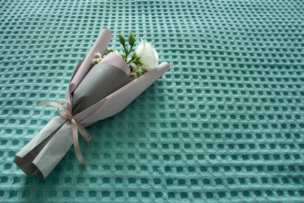 A bouquet of flowers on a turquoise background. Mothers Day. International Womens Day. The concept of the holiday.