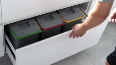 Colorful bins for sorting of plastic, paper garbage and organic waste at home. Modern kitchen with a system for sorting waste. Waste Separation Concept. Zero waste. Eco-friendly. 4K footage.