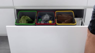 Colorful bins for sorting of plastic, paper garbage and organic waste at home. Modern kitchen with a system for sorting waste. Waste Separation Concept. Zero waste. Eco-friendly. 4K footage.