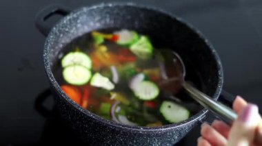 Vegetables are boiled in a casserole. Vegetables spin around in a pot with hot water. The concept of vegetarianism and healthy organic food.