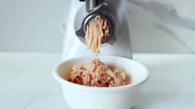 Cooking minced meat in an electric meat grinder from. The process of grinding meat in an electric meat grinder close-up. Kitchen appliances. Slow-motion.