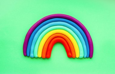 Yeşil arka planda renkli plastik gökkuşağı. Plastikten yapılmış. İzole et.