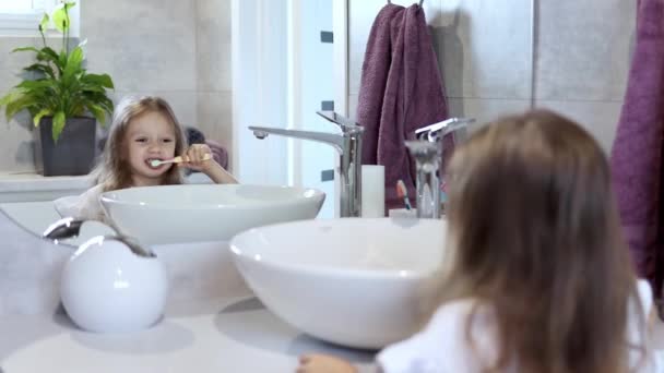 Young Little Girl Brushing Her Teeth Bathroom Looking Mirror Reflection — Stock Video