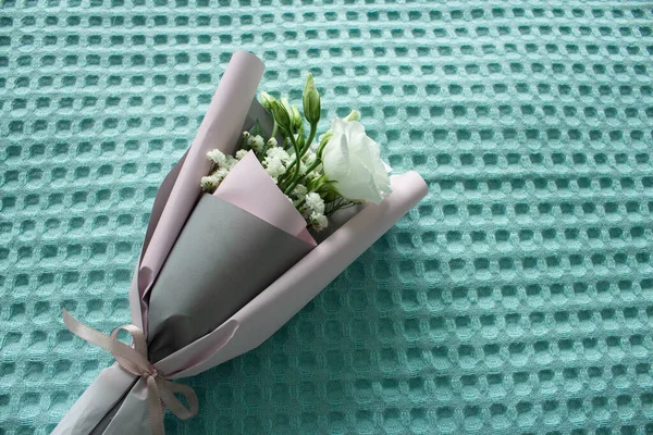 A bouquet of flowers on a turquoise background. Mother\'s Day. International Women\'s Day. The concept of the holiday.