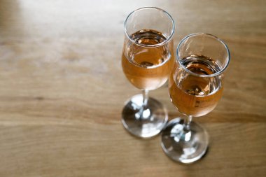 Alkollü iki bardak, seçici odak noktasında tahta bir arka planda dur. Hafta sonu tatili. Hafta sonu dinlen. Romantik bir akşam yemeği ve aperatif bekliyorum..