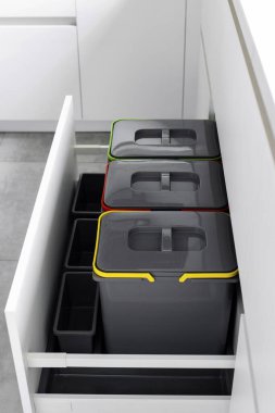 Evde plastik, kağıt çöpü ve organik atık ayıklamak için renkli kutular. Atık ayıklama sistemi olan modern bir mutfak. Atık Ayrım Konsepti. Sıfır kayıp. Çevre dostu. Dikey fotoğraf.