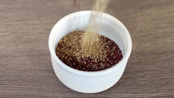 Röd Och Vit Quinoa Hälls Vit Platta Träbakgrund Slow Motion — Stockvideo