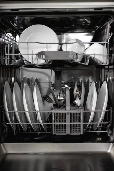 Built-in dishwasher. Clean dishes in the dishwasher. A clean white utensil. Modern technologies in the kitchen. Modern home kitchen. Housework.