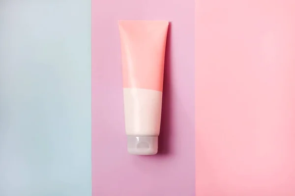 A clean label facial or body cream tube is isolated on a multi-color background. Beauty product mockup. Wellness packaging. Branding spa. Cream bottle, lotion, mousse, cleanser, shampoo for skincare routine. Copy space.