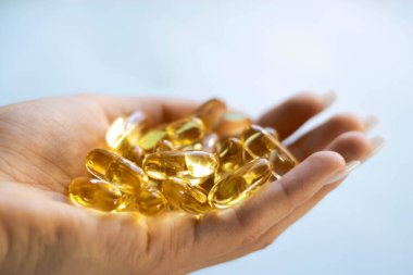 Yakın çekim sarı şeffaf haplar, omega 3 balık yağı kapsülleri, D vitamini. Yakın plan sarı şeffaf kapsüller. Sağlık, vitamin ve ilaç kavramı.