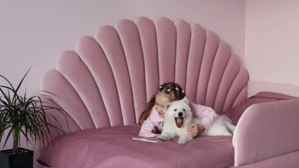 Uma Menina Está Deitada Cama Com Filhote Cachorro Branco Usando — Vídeo de Stock