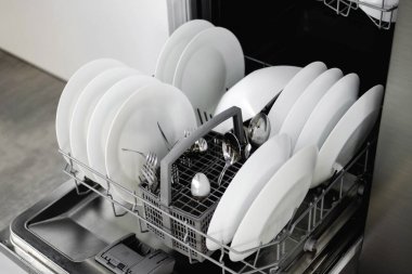 Dahili bulaşık makinesi. Bulaşık makinesinde temiz bulaşıklar. Temiz beyaz bir alet. Modern teknolojiler mutfakta. Modern ev mutfağı. Ev işleri..