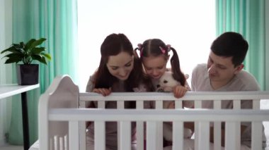 İki çocuklu mutlu bir aile ve küçük beyaz bir köpek yavrusu. Mutlu aile kavramı. Ailedeki evcil hayvan kavramı. Yavaş çekim.