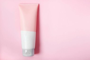 Temiz bir yüz veya vücut kremi tüpü pembe arka planda izole edilir. Güzellik ürünü maketi. Sıhhatli paket. Marka kaplıcası. Krem şişesi, losyon, köpük, temizleyici, cilt bakımı için şampuan. Boşluğu kopyala.