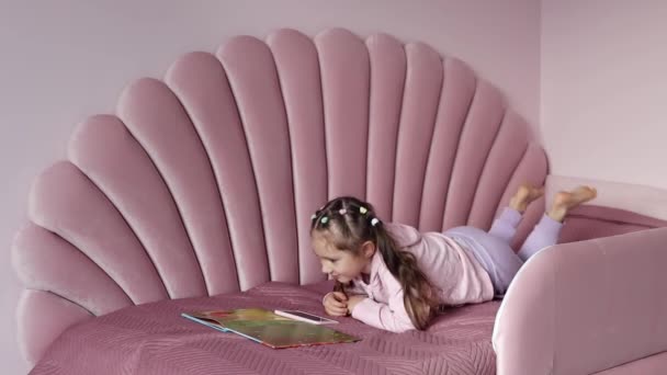 Küçük Bir Kız Kitabın Yanında Yatıyordu Cep Telefonunu Ağır Çekimde — Stok video