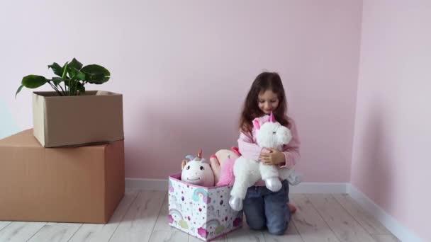 Seorang Gadis Kecil Mengambil Mainan Dari Kotak Kamar Barunya Rumah — Stok Video