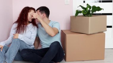 Genç ve mutlu bir çift yerde karton kutuların yanında oturuyor, koca kameraya bir sürü anahtar gösteriyor. Yeni ev. Yeni bir evin sembolü. Gayrimenkul ve kiracılık, kredi ve ipotek, taşınma