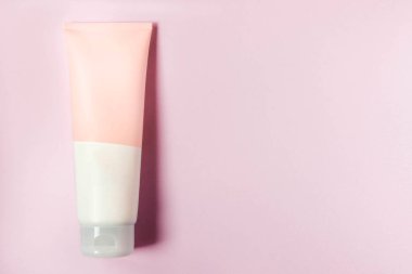 Temiz bir yüz veya vücut kremi tüpü pembe arka planda izole edilir. Güzellik ürünü maketi. Sıhhatli paket. Marka kaplıcası. Krem şişesi, losyon, köpük, temizleyici, cilt bakımı için şampuan. Boşluğu kopyala.