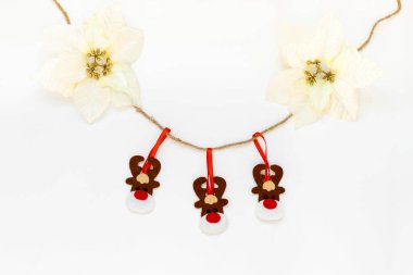 Oyuncak geyikler beyaz arka planda kopyalanmış bir ipte asılı duruyor. Noel ve Yeni Yıl atmosferi. Noel afişi, maket.