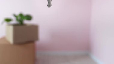 Kutuların arkasındaki eşyalarla birlikte yeni evin anahtarlarını yakın plan çek. Yeni ev. Gayrimenkul, kiracılık, kredi ve ipotek konsepti. Yavaş çekim.
