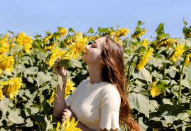 Ayçiçekleriyle dolu bir tarlada güzel bir genç kız.