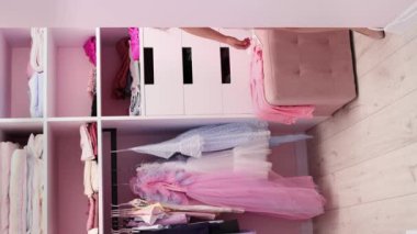 Avrupalı görünümlü küçük bir kız annesinin ayakkabılarını giyinme odasında yavaş çekimde deniyor. Biraz moda düşkünü. Moda ve tarz kavramı.