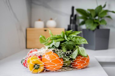 Modern mutfakta, yeniden kullanılabilir bir çantada taze sebzeler ve meyveler. Sağlıklı beslenme ve organik gıda kavramı. Market alışverişi. Sıfır israf. Eko-Arkadaş Alışverişi. Sağlıklı bir yaşam tarzı fikri.