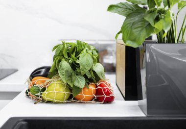 Modern mutfakta organik sebzeler ve meyveler yeniden kullanılabilir bir çantada. Market alışverişi. Sıfır israf. Eko-Arkadaş Alışverişi. Sağlıklı yaşam tarzı kavramı